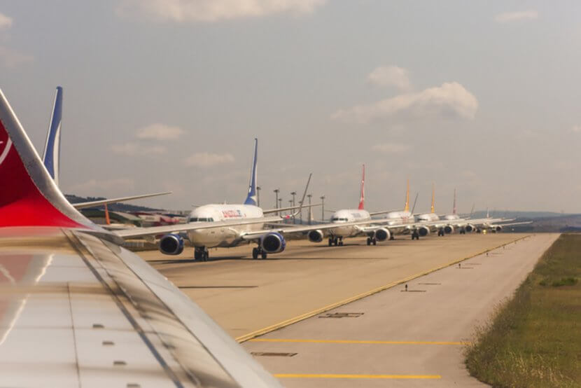 Runway full of planes queuing to taxi.