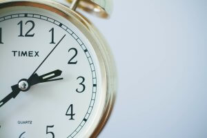 Brass alarm clock and analogue clock hands.