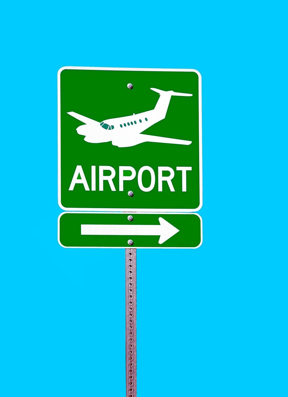 Green sign pointing to airport.