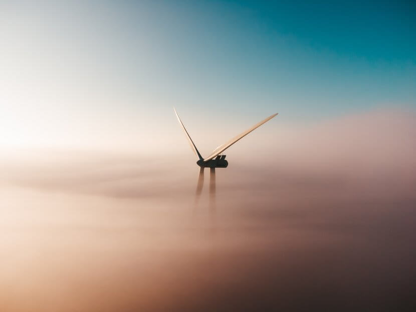 A wind turbine surrounded by mist.