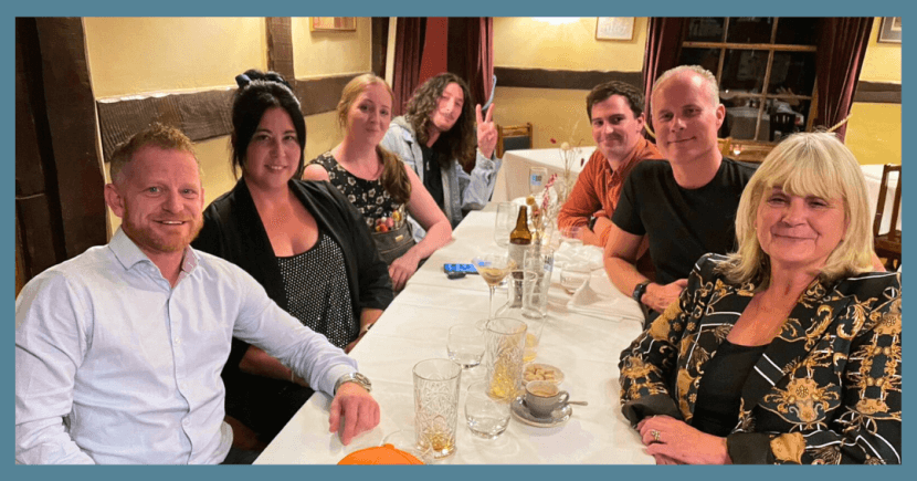 The Scarecrow team around a table having dinner.